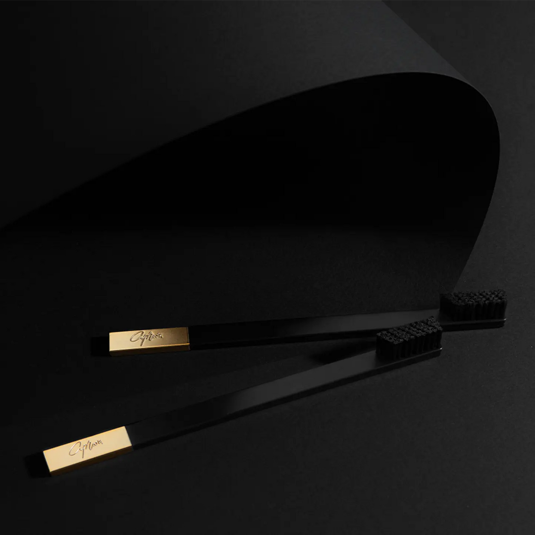Black and gold toothbrushes set on a dark background