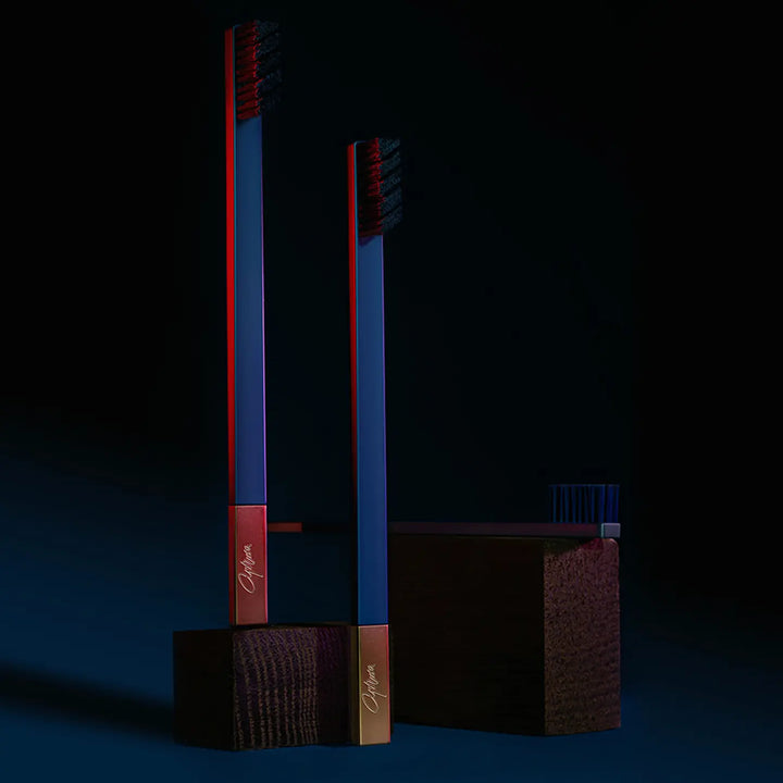 Two red and blue toothbrushes on a dark background