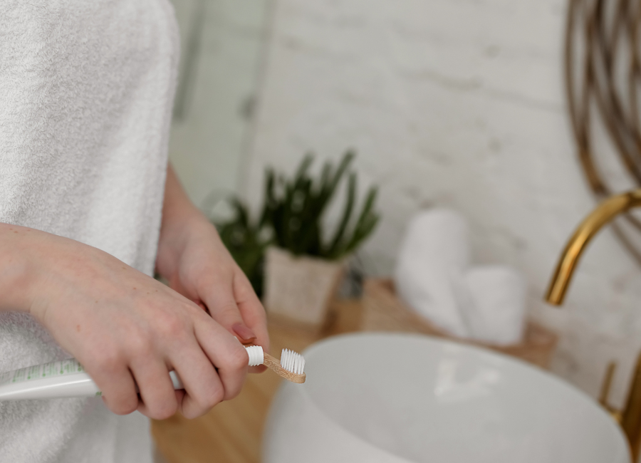 Woman squeezing toothpaste onto toothpaste in serene bathroom