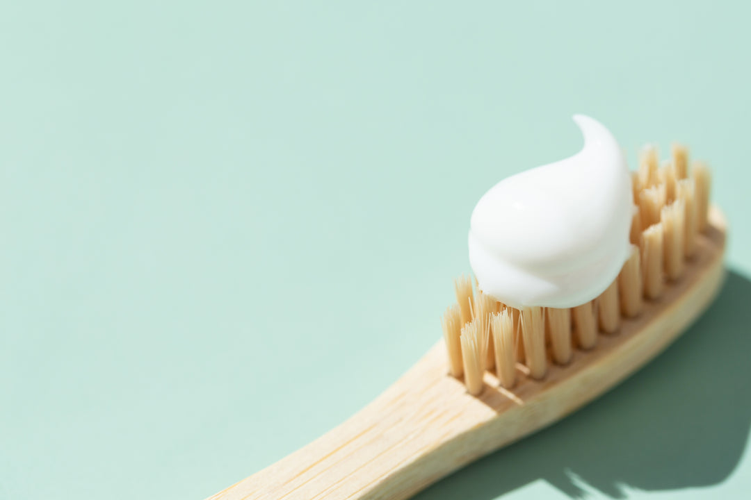 White toothpaste on natural bamboo toothbrush
