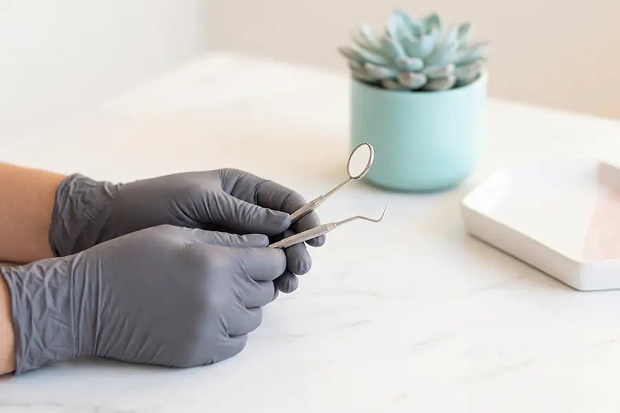 Dental professional hands with mirror and explorer tool in a modern boutique practice