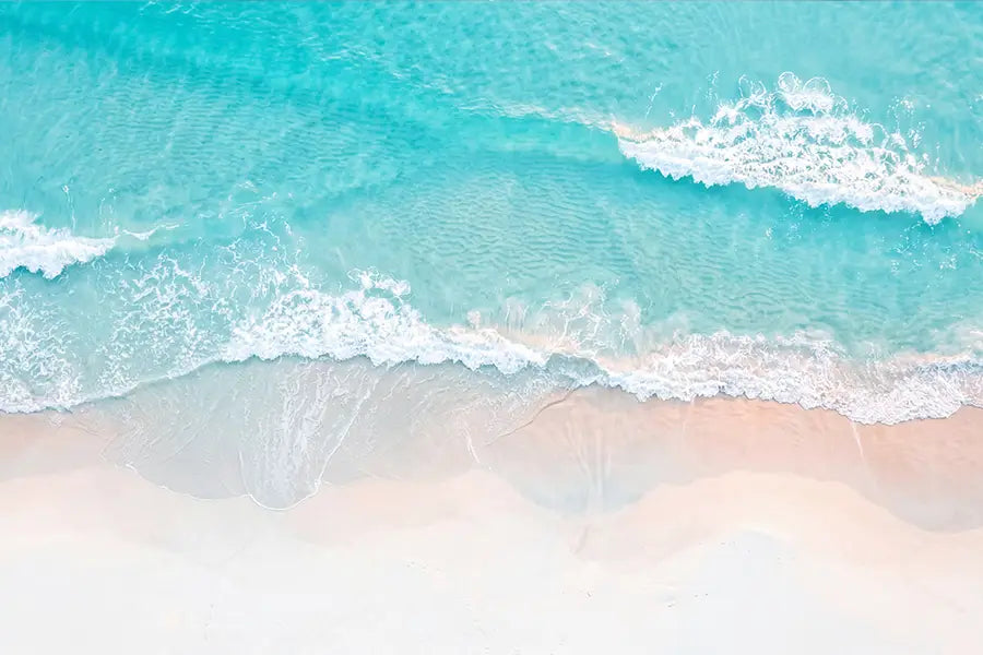 Aerial view of turquoise Australian ocean wave meeting white sand beach