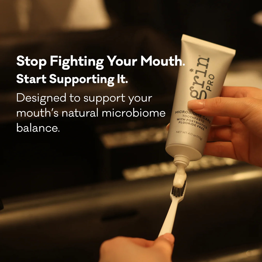 Squeezing Grin Pro Microbiome Care toothpaste onto a toothbrush in a dark bathroom — brand campaign graphic