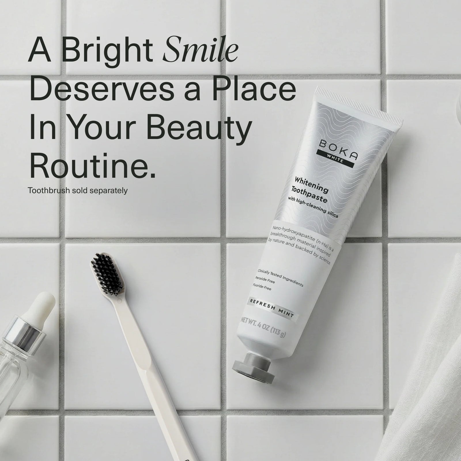 Boka Refresh Mint whitening toothpaste tube on white tiles beside a toothbrush