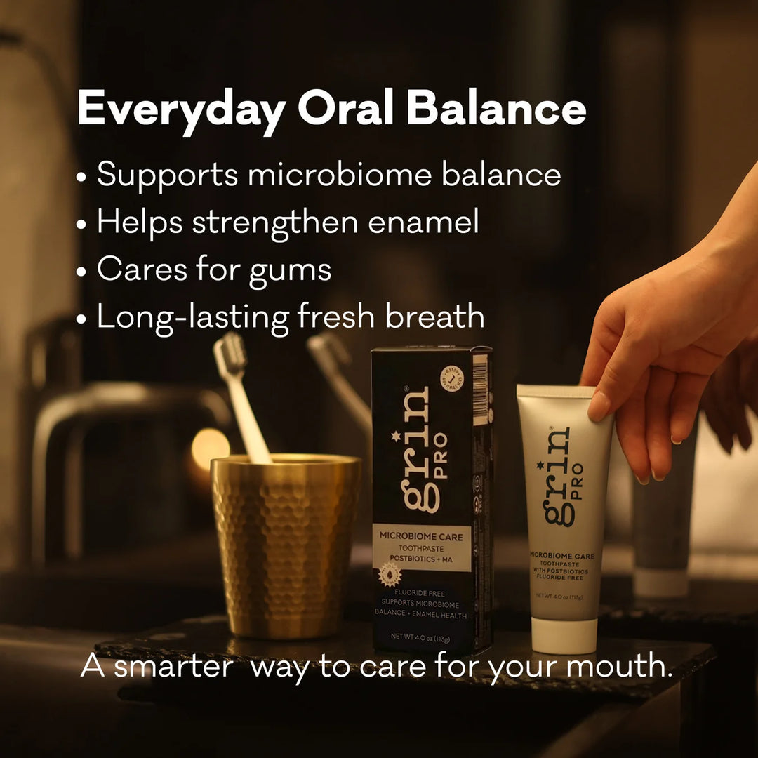 Grin Pro Microbiome Care toothpaste box and tube on a bathroom vanity with a brass cup and toothbrush — everyday oral balance