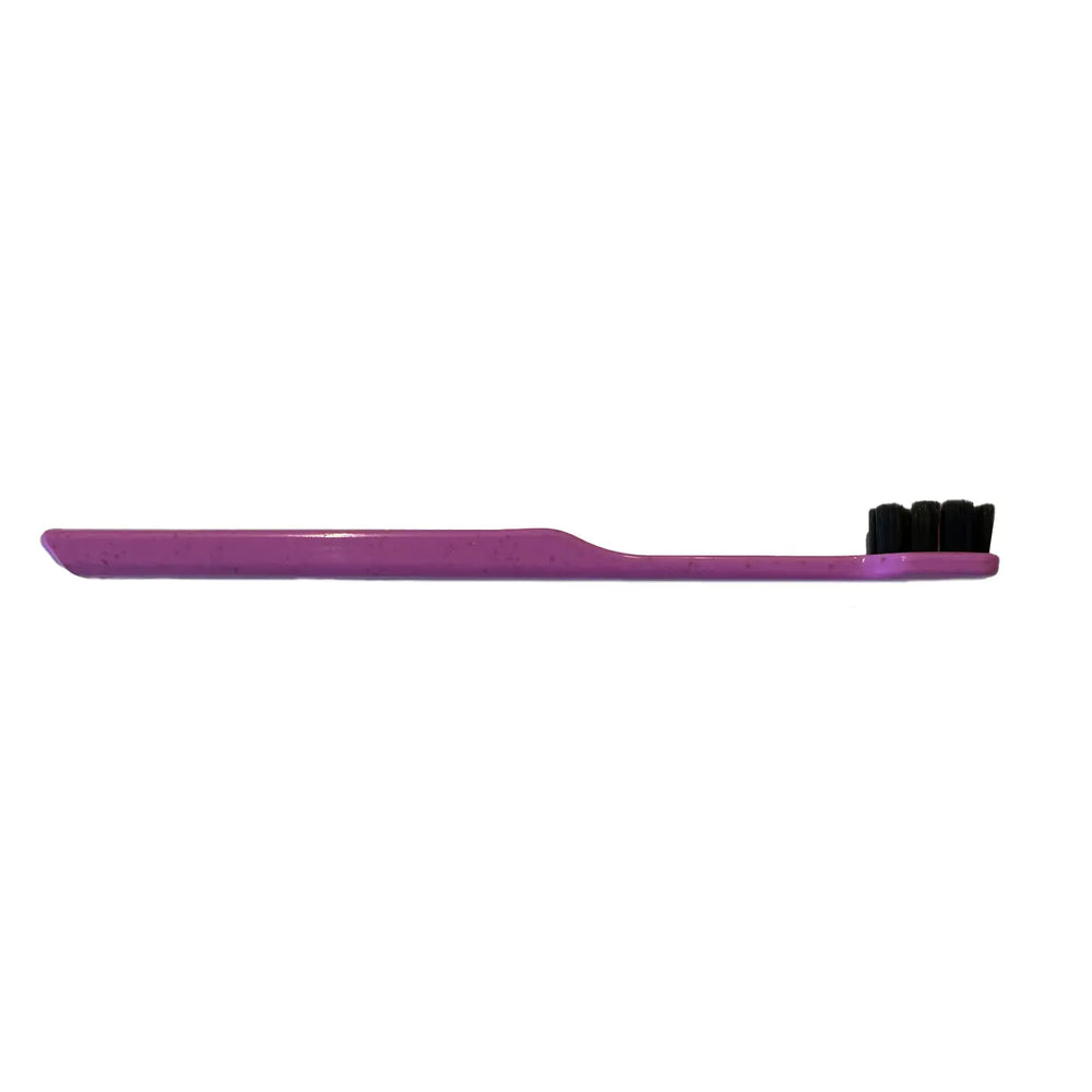 Purple toothbrush with black bristles on a white background