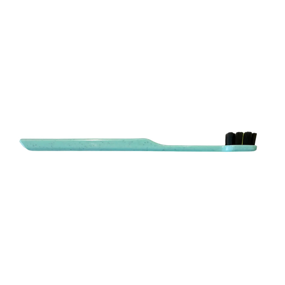 Teal toothbrush with black bristles on a white background