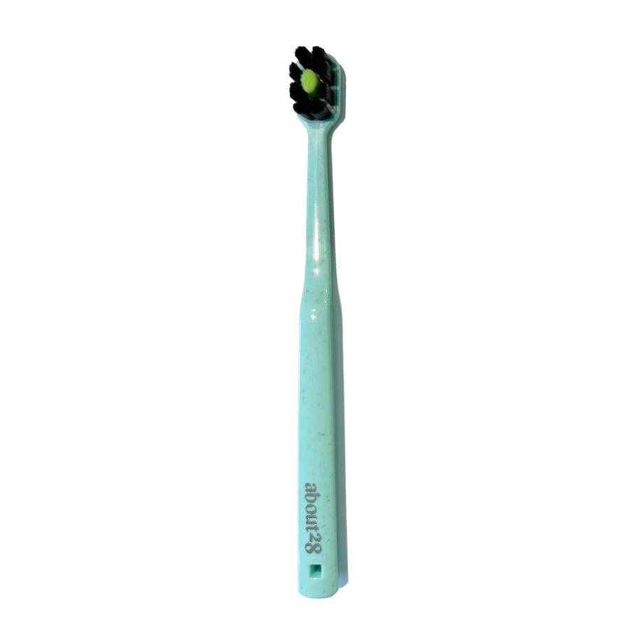 Light mint toothbrush with black bristles on a white background