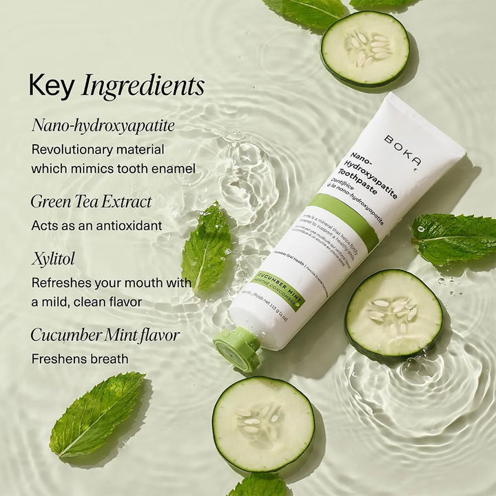 Boka Cucumber Mint toothpaste in shallow water with cucumber slices and mint leaves beside a key ingredients list