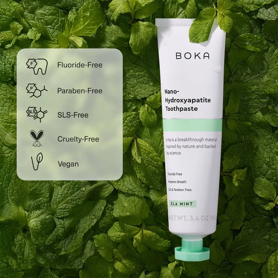 Boka Ela Mint toothpaste tube on mint leaves with icons: fluoride-free, paraben-free, SLS-free, cruelty-free, vegan