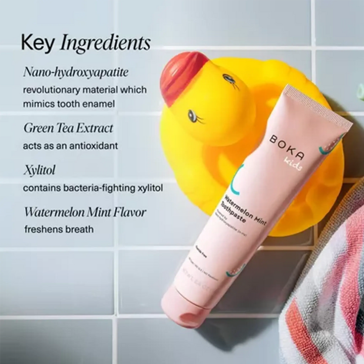 Boka Kids toothpaste tube with a rubber duck and towel on a tiled background