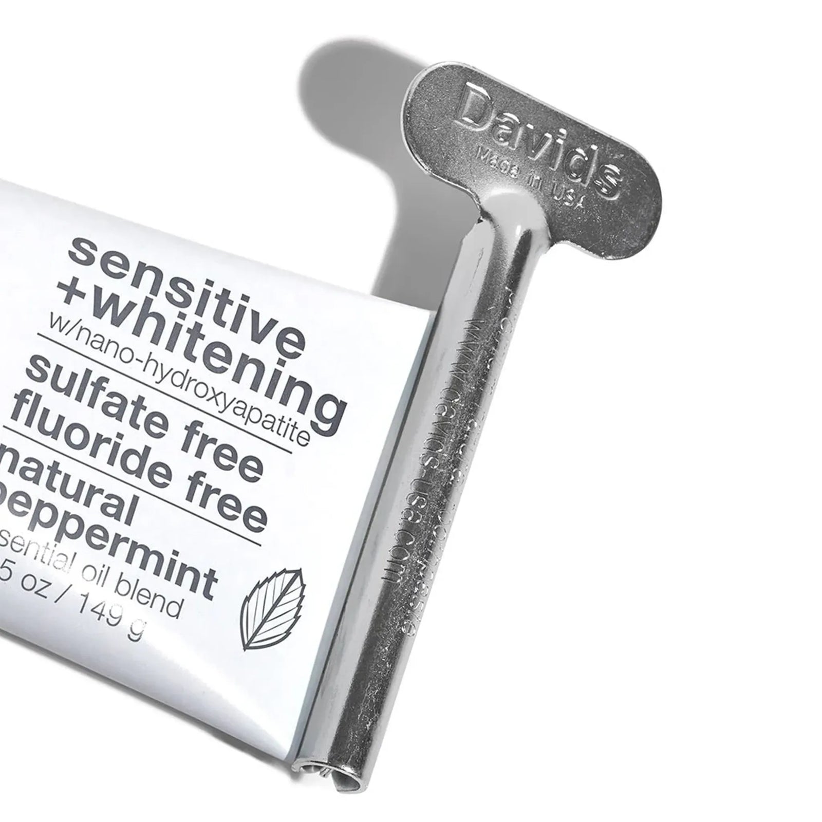 Davids metal tube key squeezer rolling up a Davids toothpaste tube, 'Made in USA' embossed on the key