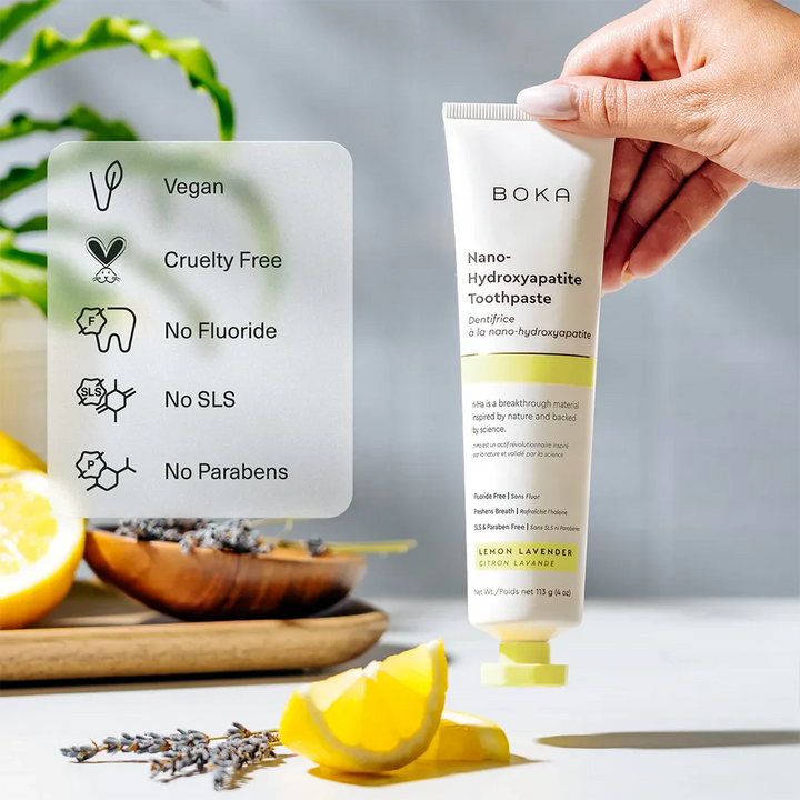 Hand holding a Boka Lemon Lavender toothpaste tube beside icons for vegan, cruelty free, no fluoride, no SLS and no parabens