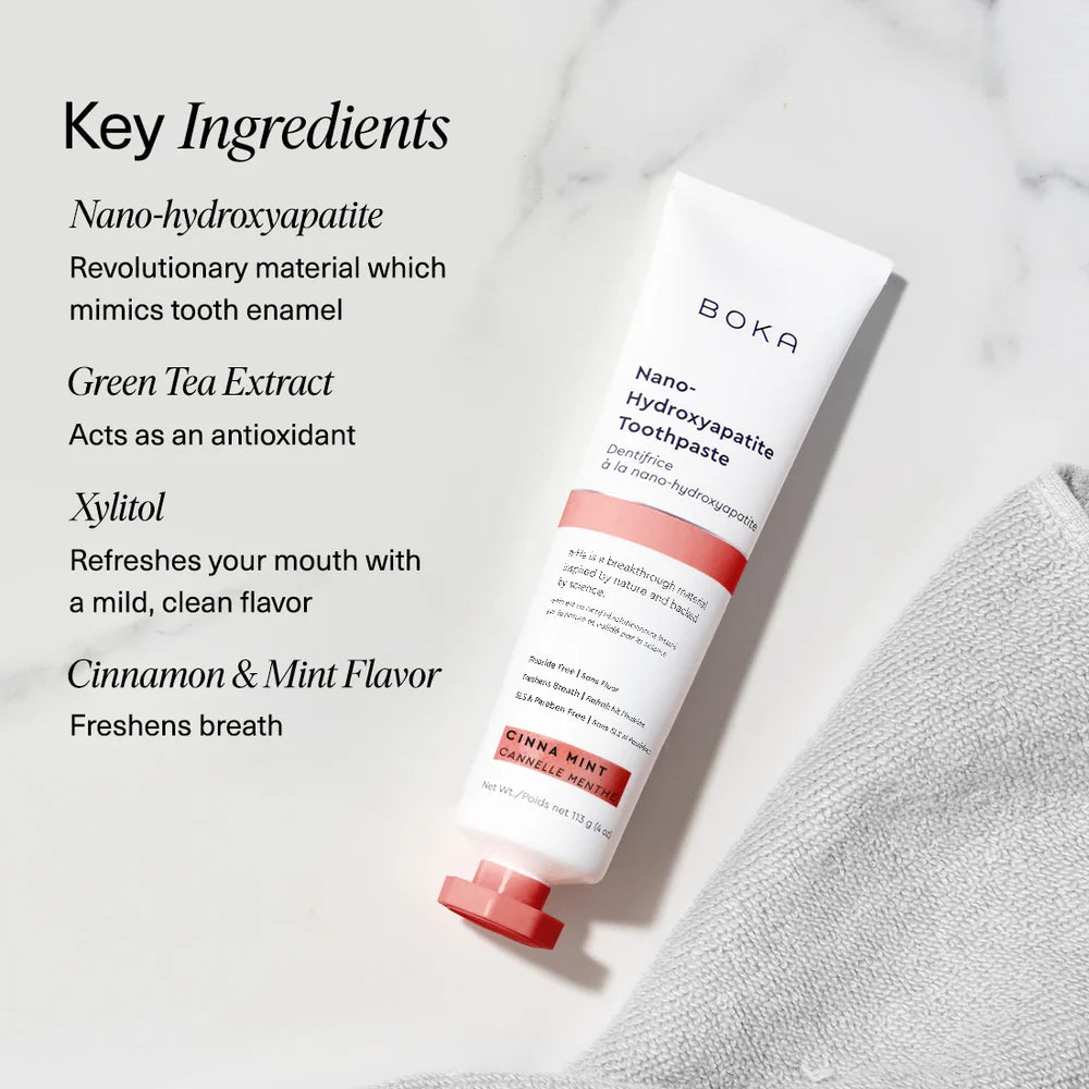 Boka Cinna Mint toothpaste on marble beside nano-hydroxyapatite, green tea, xylitol and cinnamon callouts