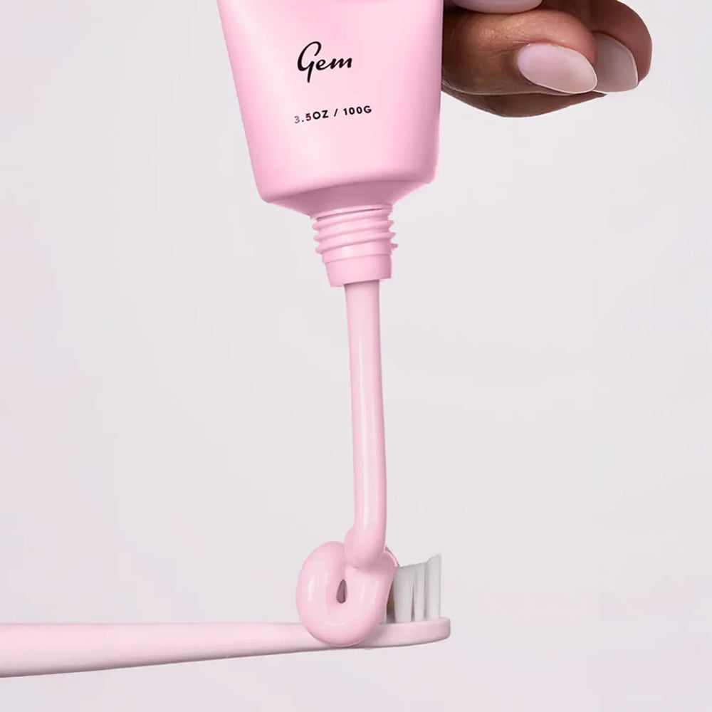Pink toothpaste with a pump dispenser labeled 'Gem' on a light gray background