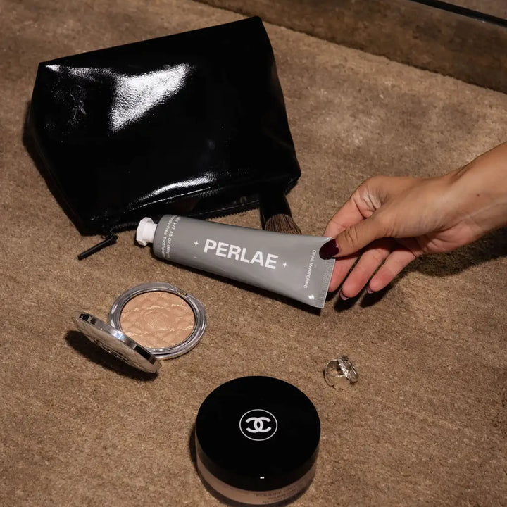 Woman holding Perlae Opal Whitening Toothpaste — clean vegan fluoride free oral care