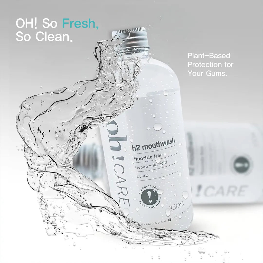 Oh Care h2 mouthwash bottle with a splash of clear liquid arcing around it, an Oh Care toothpaste carton blurred behind