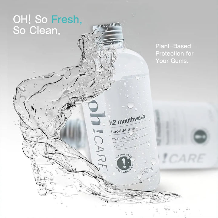 Oh Care h2 mouthwash bottle with a splash of clear liquid arcing around it, an Oh Care toothpaste carton blurred behind